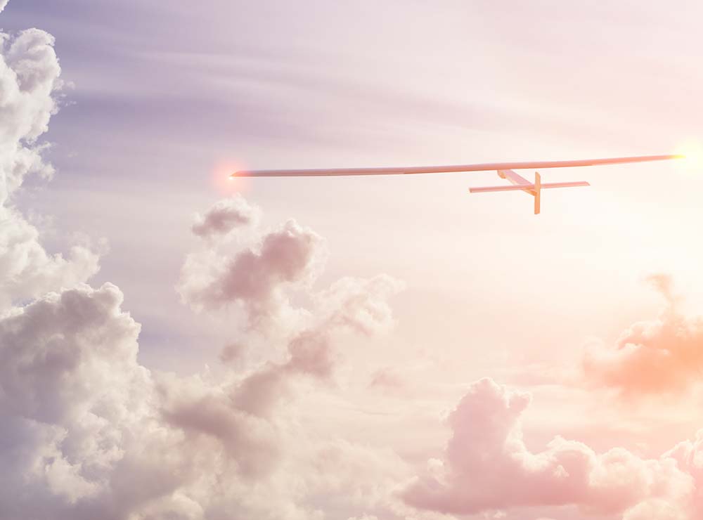 Leidenschaft: Solar Impulse in bewölktem Himmel mit Sonnenlicht.